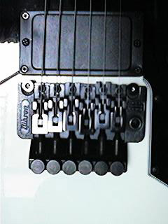 Close detail of the Floyd Rose tremolo on an Alpine White Gibson V90 Double